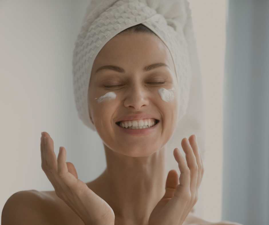 Smilende kvinne som bruker hudpleie med naturlige ingredienser